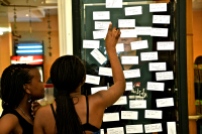 2012, 'Label', Maerua Mall, Windhoek, Namibia.Wechslberger stood in the self-made glass box and provided people andpassers-by, her co-actors, with stickers and markers to label her.